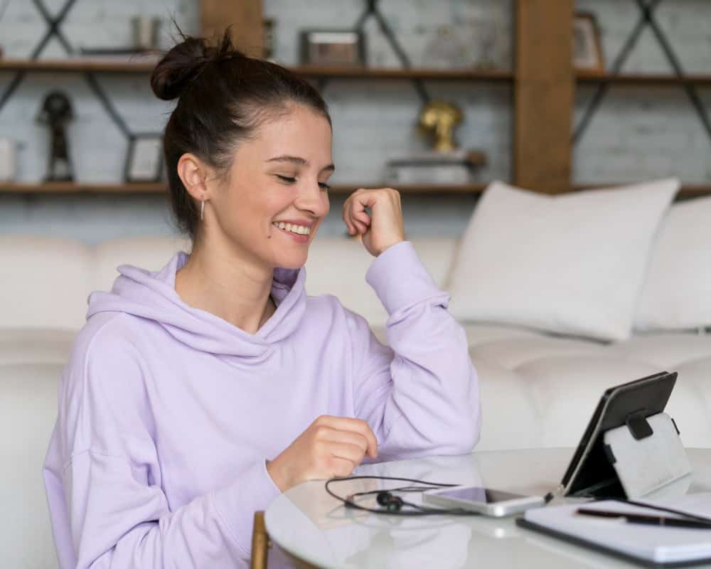 Woman using tablet at home during telehealth addiction treatment in Washington session